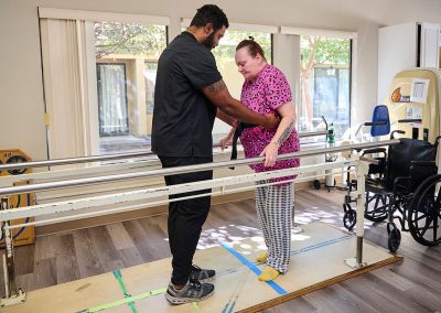 A physical therapist helping a woman to walk